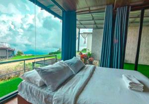 a bedroom with a bed and a large window at วันเดย์ภูทับเบิก in Ban Maeo Thap Boek