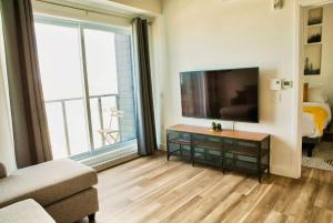 a living room with a television and a large window at Caïman - Le1006 in Quebec City