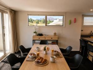 a dining room with a table and chairs and a window at Alpine Vista with Mountain Views, Pool and Spa in Wanaka