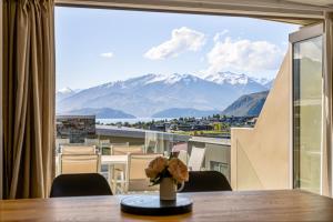 a room with a table and a view of mountains at Alpine Vista with Mountain Views, Pool and Spa in Wanaka