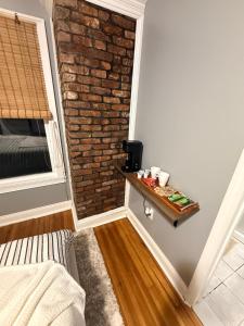 a small room with a brick wall and a table at Grey comfort room in New London