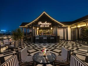 a bar with chairs and a table on a patio at THE LEGEND HANOI Hotel in Hanoi