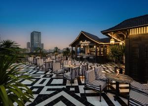 a row of chairs and tables on a patio at THE LEGEND HANOI Hotel in Hanoi