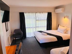 a hotel room with two beds and a window at Awatea Park Motel in Palmerston North