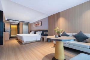 a hotel room with a bed and a table at YIBON INTERNATIONAL HOTEL in Guiyang