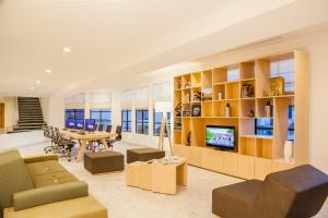 a living room with a dining table and a television at Fiesta Inn Saltillo in Saltillo