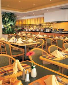 a restaurant with tables and chairs and a kitchen at Fiesta Inn Saltillo in Saltillo +37 photos