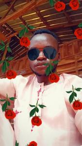 ein Mann mit Sonnenbrille und Rosen im Gesicht in der Unterkunft Multipelea in Kano