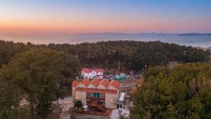 an aerial view of a house with the ocean in the background at Taean Atirans Beach Pension in Taean