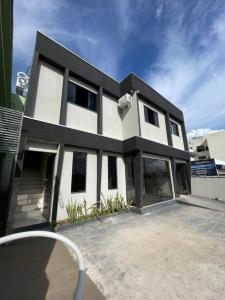 a white and black house with a lot of windows at Apartamento Colinas in Cacoal