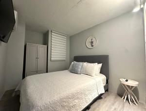a small bedroom with a bed and a clock on the wall at Gema del Mar, Vieques, PR in Vieques