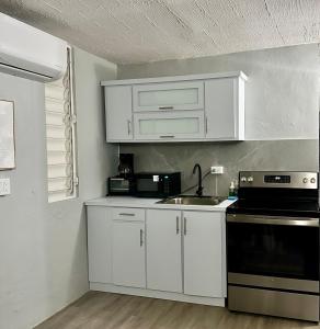 a kitchen with white cabinets and a sink at Gema del Mar, Vieques, PR in Vieques