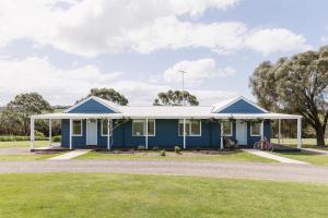 a blue house with a white roof at Suma Park Estate in Point Lonsdale