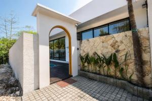 a house with a stone wall and a doorway at Santo Villa Uluwatu in Bingin Beach