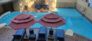 an overhead view of a swimming pool with umbrellas at THE PALM's BED AND BREAKFAST IN ARPORA in Arpora