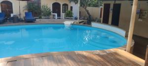 a large blue swimming pool with a wooden deck at THE PALM's BED AND BREAKFAST IN ARPORA in Arpora