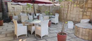 a group of white chairs and tables and an umbrella at THE PALM's BED AND BREAKFAST IN ARPORA in Arpora