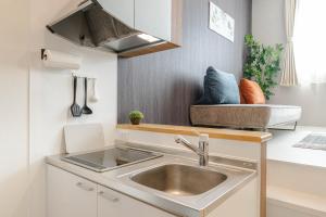 a small kitchen with a sink and a couch at iisa307 in Isahaya +285 photos