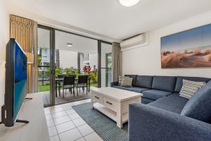 a living room with a blue couch and a tv at Sand Dunes Resort Accommodation in Marcoola