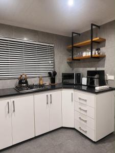 a kitchen with white cabinets and black counter tops at Villa da Lucia in St Lucia +3 photos