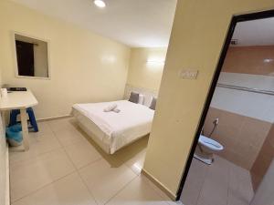 a room with a bed and a bathroom with a toilet at Happiness Hotel in Kulai