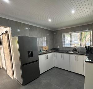 a kitchen with a stainless steel refrigerator and white cabinets at Villa da Lucia in St Lucia