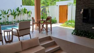 a living room with a couch and a table and chairs at Taluna Villas in Panglao Island