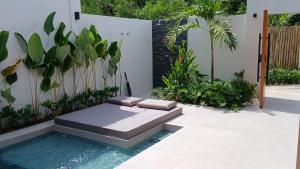 a garden with a bench in the middle of a pool at Taluna Villas in Panglao Island