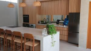 a kitchen with a counter with chairs and a refrigerator at Taluna Villas in Panglao Island