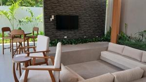 a living room with a couch and chairs and a tv at Taluna Villas in Panglao Island