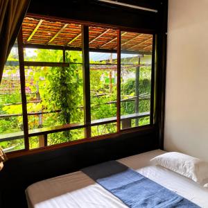 a bedroom with a bed and a window with a view at Vũ Di Homestay in Hue
