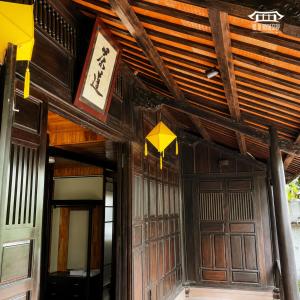 a building with a wooden ceiling and wooden doors at Vũ Di Homestay in Hue