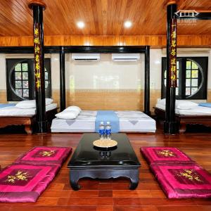a room with two beds and a table and red mats at Vũ Di Homestay in Hue +18 photos