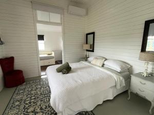 a bedroom with a large white bed and a window at Oakmore Cottage Charming Old Vintage Queenslander - Central location in Bundaberg