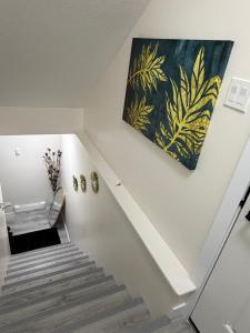 a staircase with a painting on the wall at Havilah Cozy in Regina