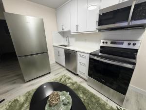 a kitchen with stainless steel appliances and a table at Havilah Cozy in Regina +1 photo