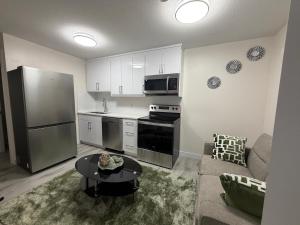 a kitchen with a refrigerator and a table in a living room at Havilah Cozy in Regina