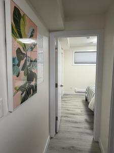 a hallway leading to a bedroom with a painting on the wall at Havilah Cozy in Regina