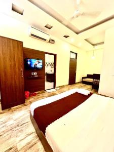 a bedroom with a bed and a flat screen tv at Hotel Wooodcrestt Zirakpur in Zirakpur