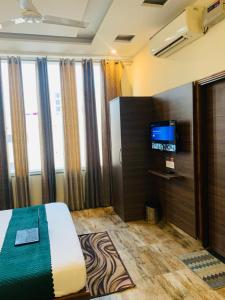 a bedroom with a bed and a television in it at Hotel Wooodcrestt Zirakpur in Zirakpur