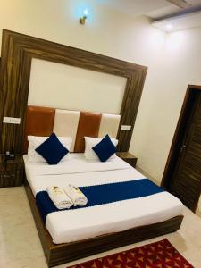 a bedroom with a large bed with blue and white pillows at Hotel Wooodcrestt Zirakpur in Zirakpur