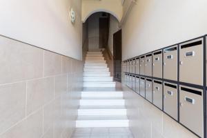 korytarzem z zamykanymi szafkami i schodami w budynku w obiekcie Casa Cosi Sant Antoni w Barcelonie