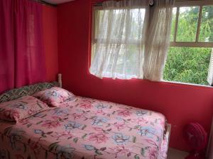a bedroom with a bed in front of a window at Pousada Recanto Gramado in Gramado