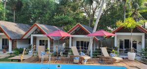 a house with chairs and umbrellas next to a pool at lala-Oh Resort in Lalao