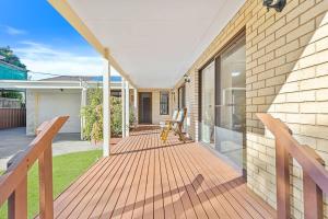 a wooden deck with a bench on a house at Winnies on Sunpatch in Tomakin