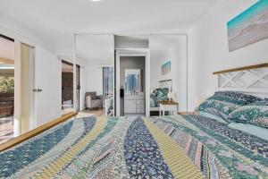a bedroom with a king sized bed and a desk at Winnies on Sunpatch in Tomakin +8 photos