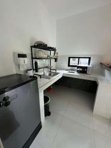 a kitchen with a sink and a desk with a laptop at Khao Raa Terrace 6 in Ko Phangan