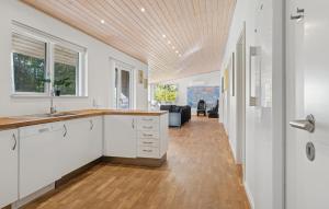 a kitchen with white cabinets and a wooden ceiling at Awesome Home In Bording With Sauna in Korning