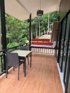 a porch with a table and chairs and a bench at Khao Raa Terrace 6 in Ko Phangan