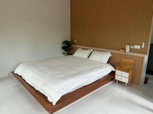 a bedroom with a bed with white sheets and a nightstand at Khao Raa Terrace 6 in Ko Phangan +4 photos